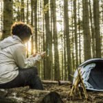 Woman using mobile phone while camping