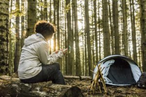Woman using mobile phone while camping