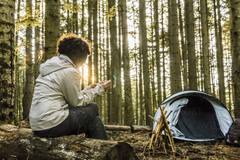 Woman using mobile phone while camping